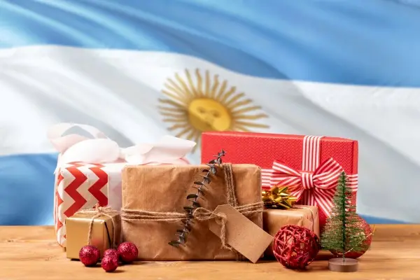 Christmas gifts stacked next to a waving Argentine flag.