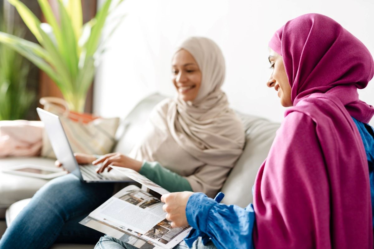 Middle-eastern mother's day: mother and daughter smiling and relaxing together at home on a couch.