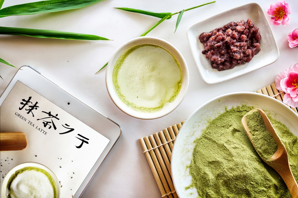 matcha tea gift set, green tea latte and tablet computer on white table background